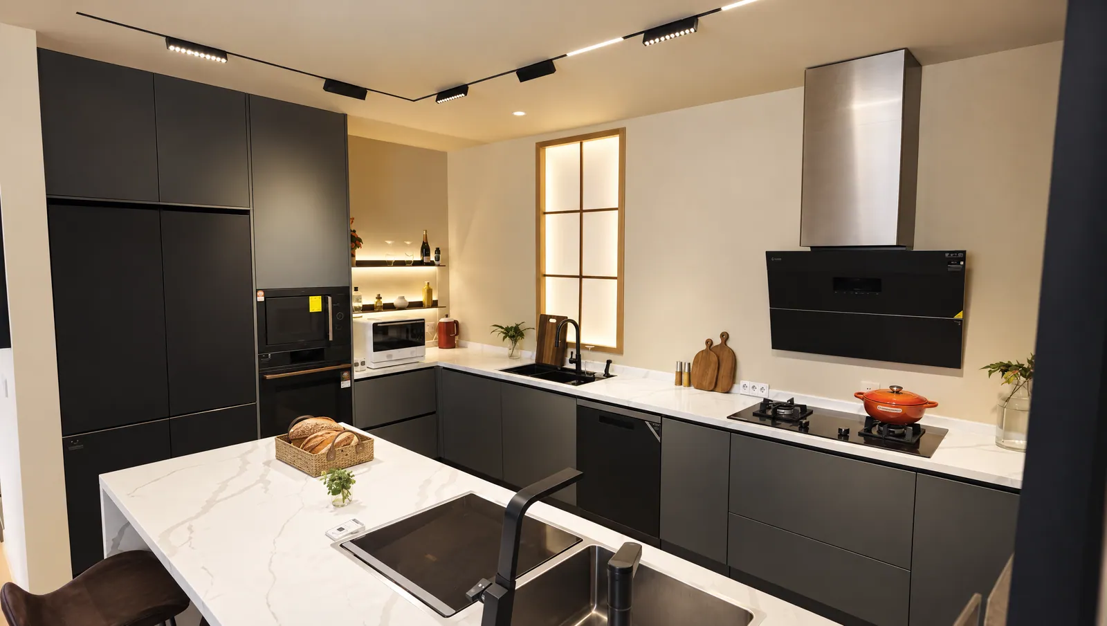 Real Cabchen showroom kitchen: graphite cabinets, tall appliance units, stainless chimney hood and a marble-look island with sink